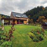 Súčasná prírodná architektúra. Aby dom dokonale zapadol do prostredia horskej doliny, obložili jeho steny drevom bez farebnej povrchovej úpravy. Farebnosť dreva decentne dopĺňa tmavosivá hliníková strecha, okenné rámy a ďalšie detaily v rovnakom antracitovom odtieni.