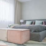 Čalúnená posteľ s poduškami v pastelových tónoch