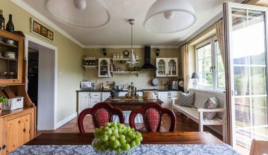 Obývačka spojená s kuchyňou v rustikálnom štýle s jedálenským stolom a stoličkami
