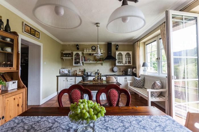 Obývačka spojená s kuchyňou v rustikálnom štýle s jedálenským stolom a stoličkami