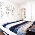 spálňa s posteľou, modré obliečky, mapa sveta