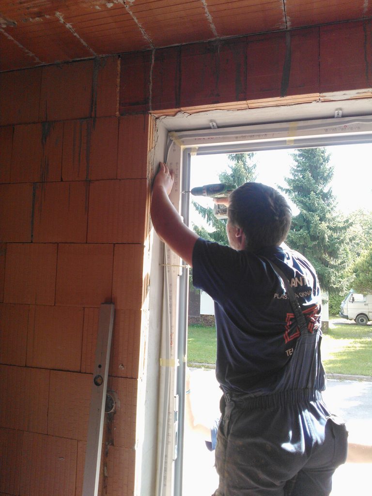 Okenný rám sa zafixuje v správnej polohe pomocou samorezných skrutiek, navŕtaných cez rám okna a plochých kotiev priskrutkovaných na rozperky (tzv. hmoždinky). Skrutky sa dotiahnu tak, aby sa zabránilo deformácii alebo prehnutiu rámu.